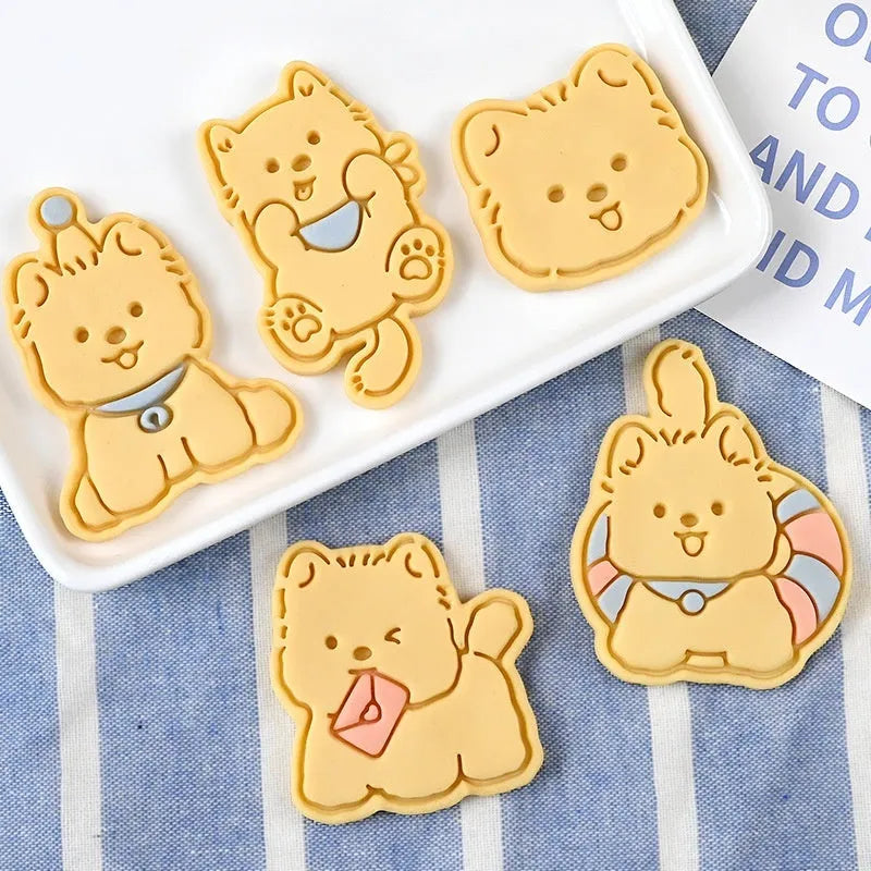 Three dimensional plastic biscuit mould showing puppy cartoon designs including birthday hats and swimming rings