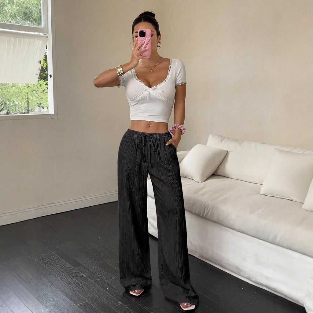 Women's black wide leg trousers with lace-up waist detail on hanger