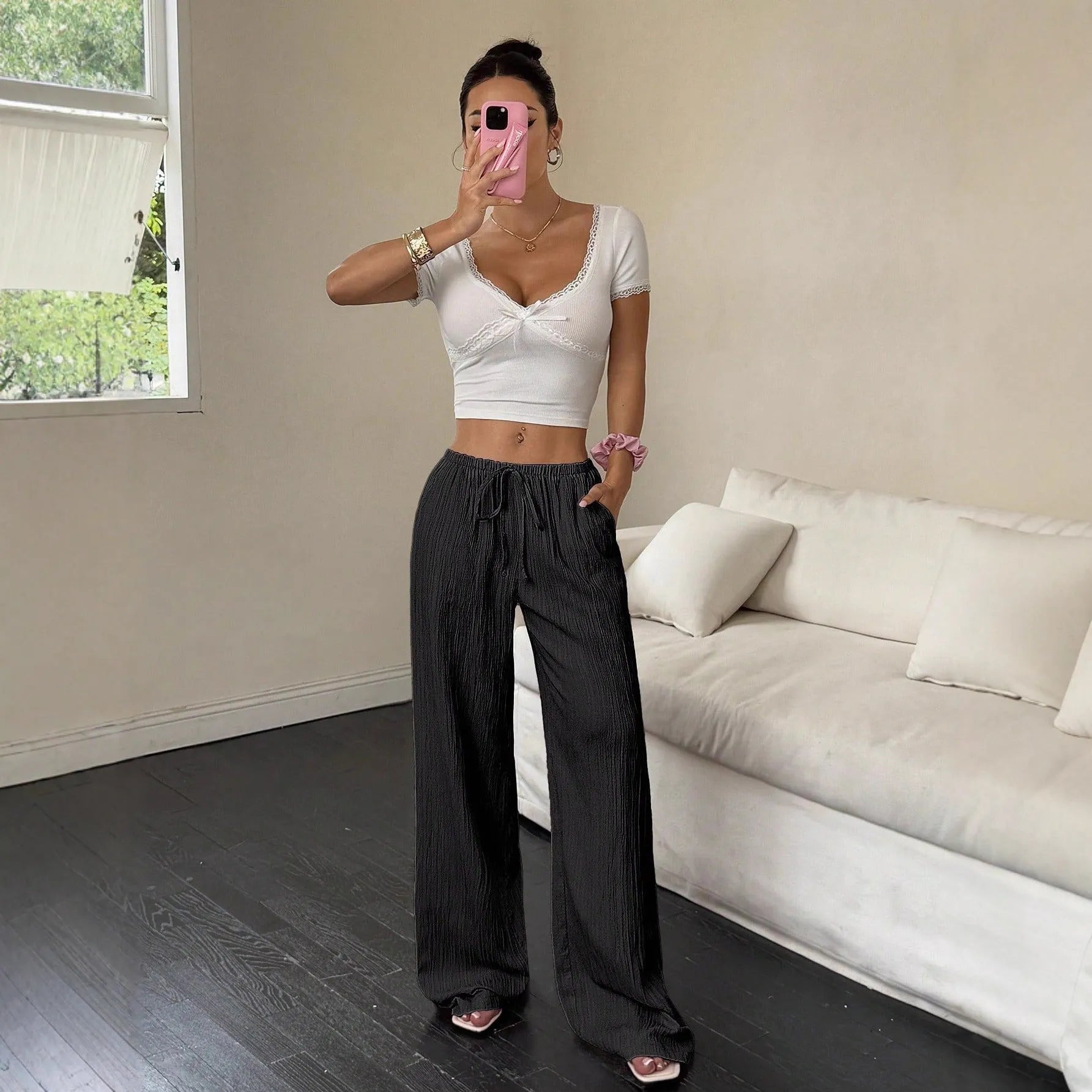 Women's black wide leg trousers with lace-up waist detail on hanger