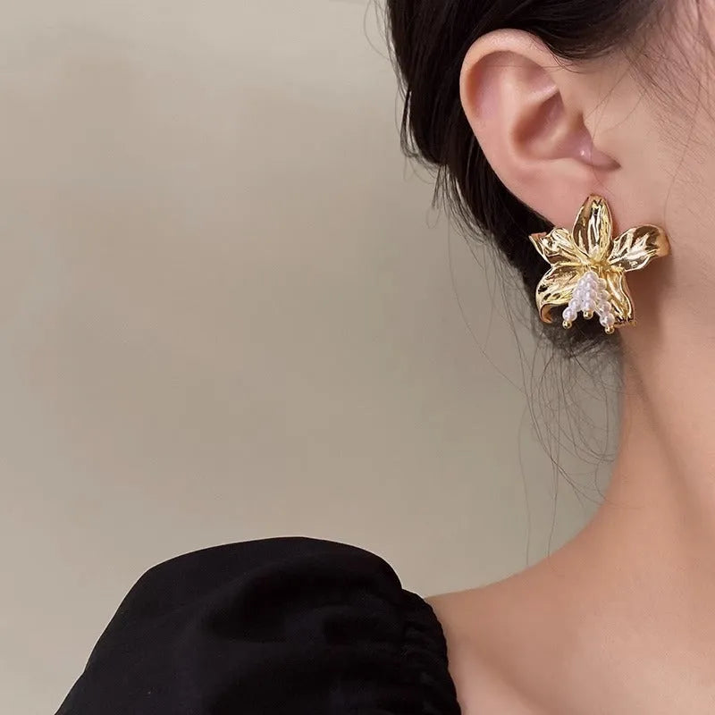 Gold H1795 metal flower earrings with pearls and an exaggerated, personalised design.