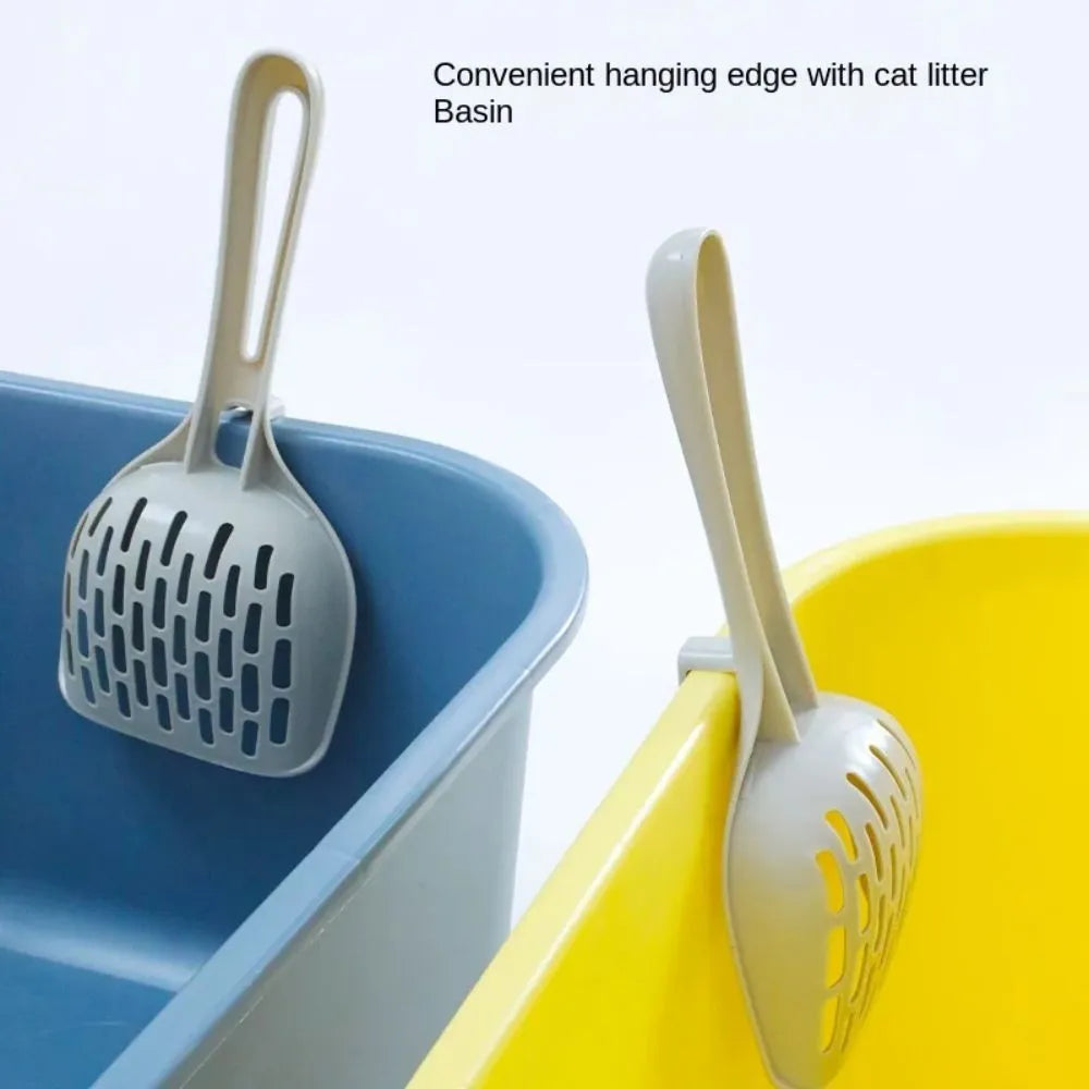 Grey plastic cat litter scoop with handle sitting upright in its integrated square base.