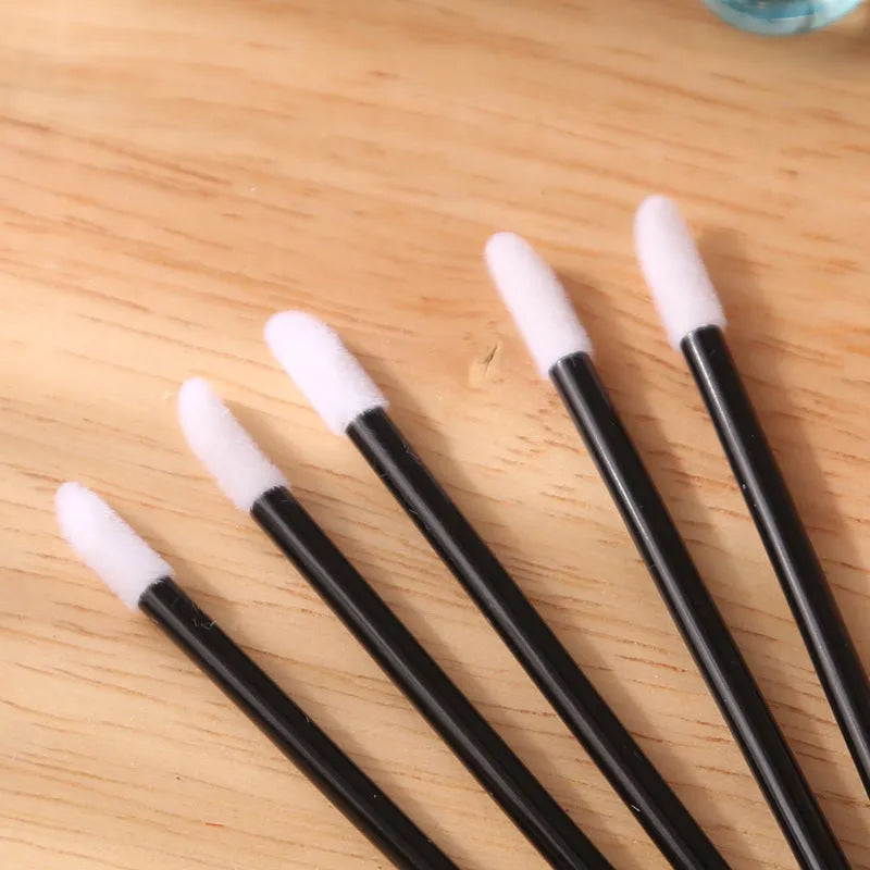 Disposable lip brush applicators with flocked heads in multiple handle colours on white background