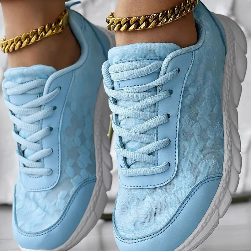 Women's white canvas casual sports running shoe with round toe and flat heel on a neutral background.