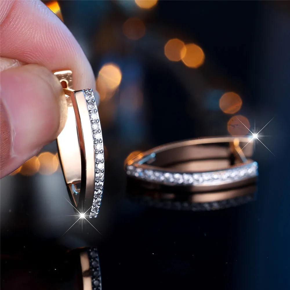 Women's geometric drop earrings with champagne gold electroplating and white diamond accents, showing V-shaped design and clip-on back.