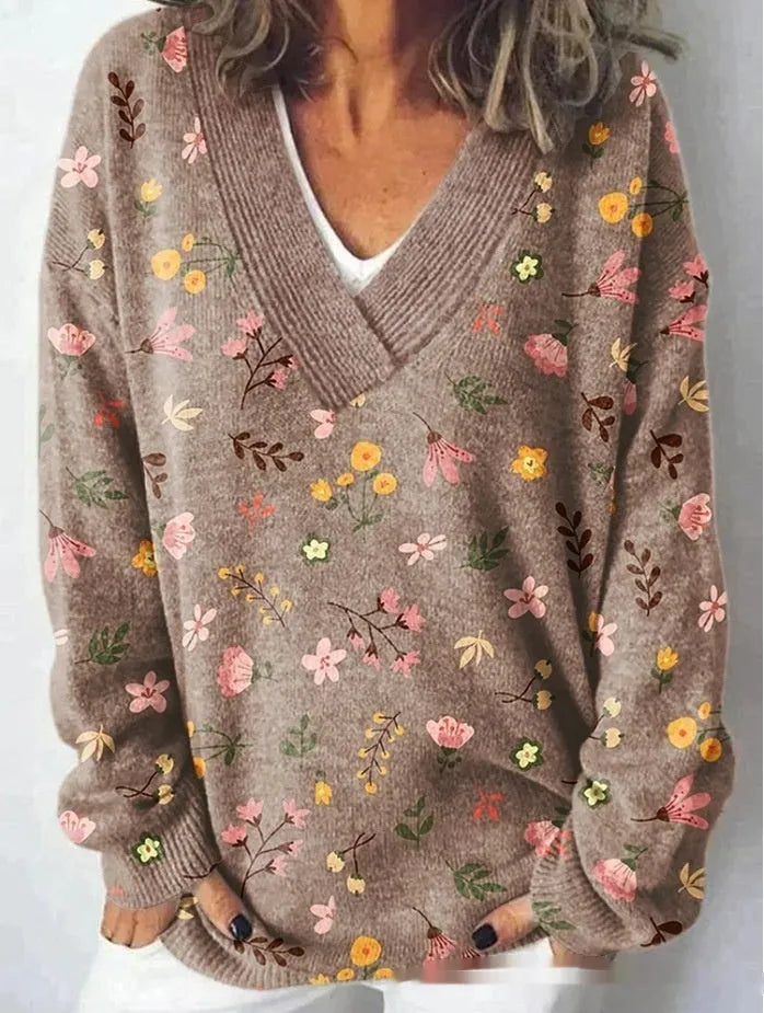 Women's white floral print V-neck sweatshirt with 3D pattern and long sleeves on a hanger.