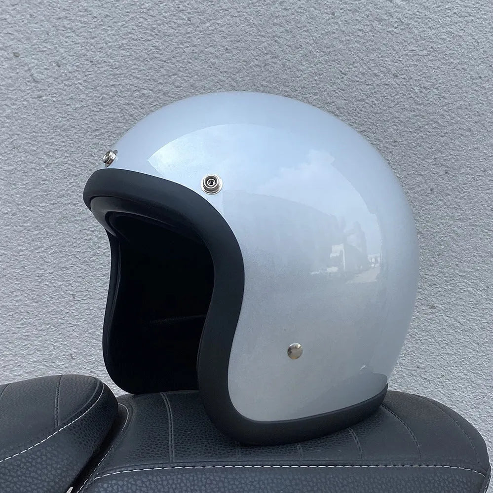 Glass fibre retro half motorcycle helmet shown in multiple colour options including cement grey and matte black flower patterns