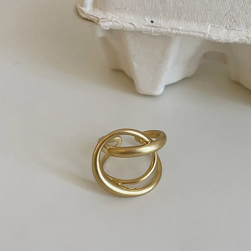 Geometric interlaced matte metal open ring for women in gold or silver.