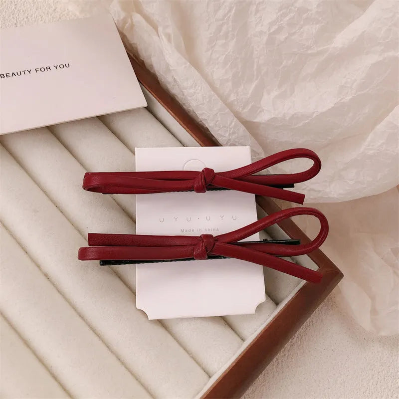 Wine red leather bow hair barrette showing bow design and clip mechanism