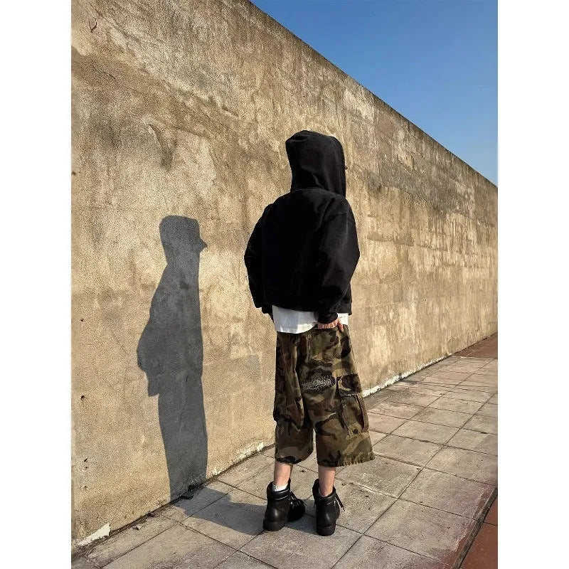 Men's camouflage cropped jeans with patchwork detailing and distressed rips in loose straight-leg fit