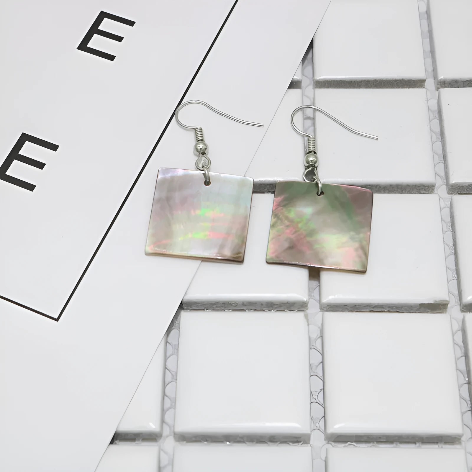 A pair of geometric-shaped women's earrings made from natural shell in a retro style.