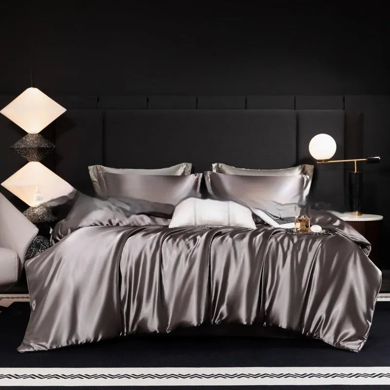 Solid colour silk bedding four-piece set shown in twilight blue on a bed.