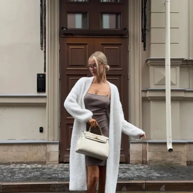White longline women's cardigan jacket with long sleeves made from thick polyester knit fabric.