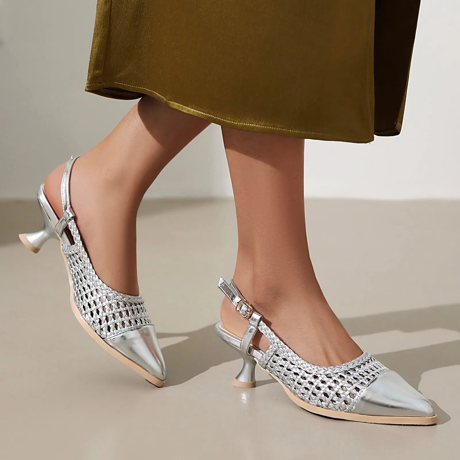 Gold women's sandals with a cat heel and ankle buckle on a white background.