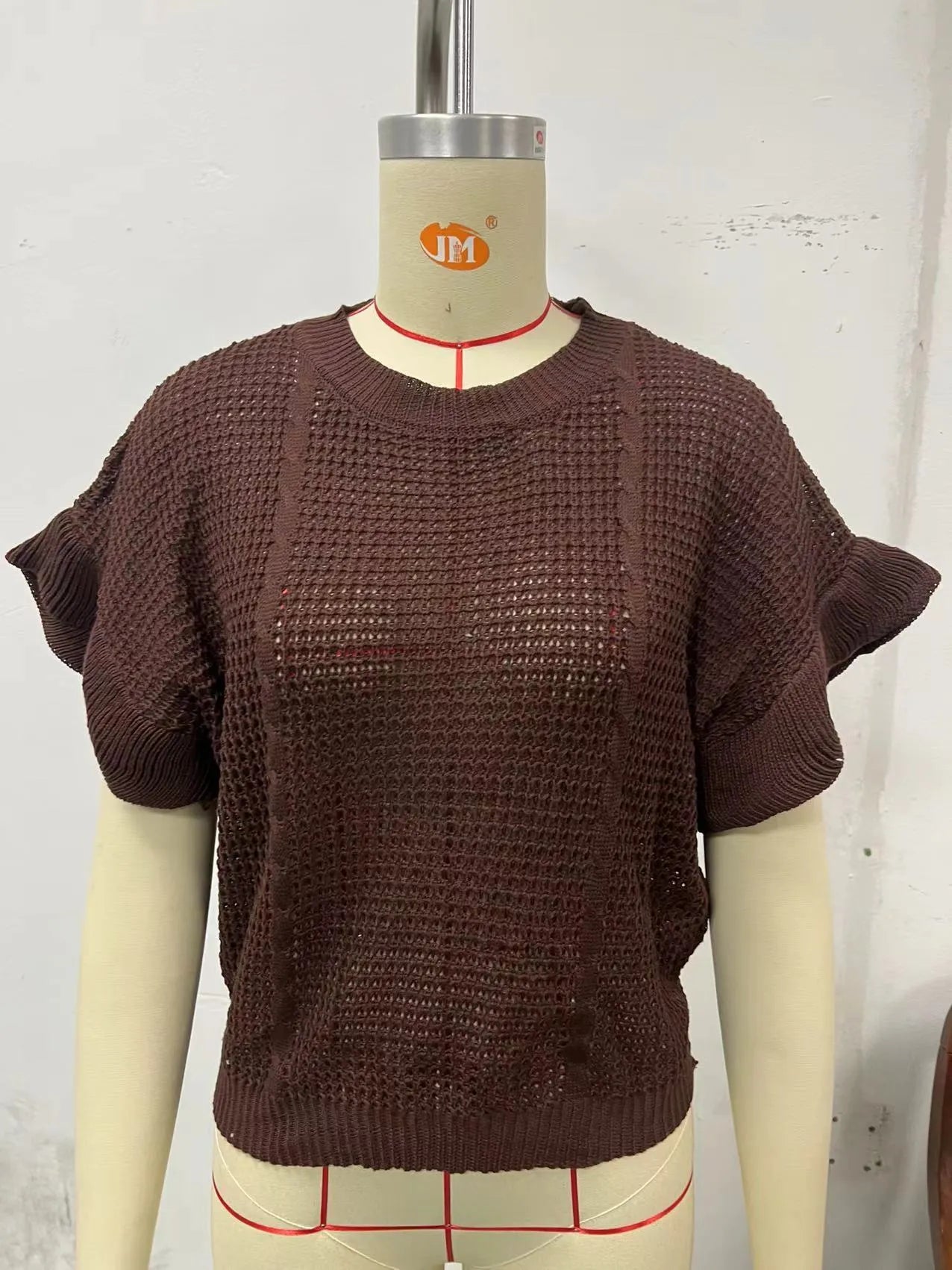 Loose fit knitted pullover sweater with ruffled short sleeves and twisted string design detailing