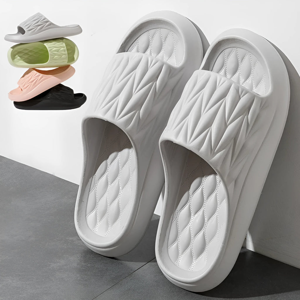 Pair of leaf-textured EVA indoor slippers on a solid background, showing non-slip sole.