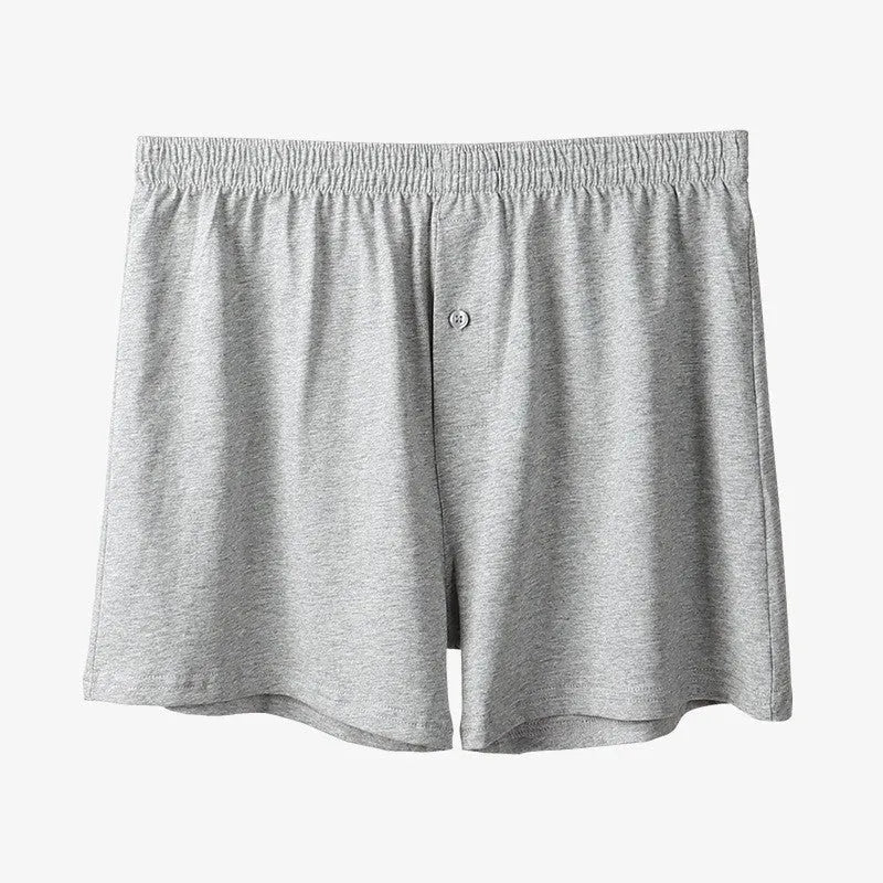 Men's solid colour loose-fit cotton boxer shorts on a white background, showing high waist and leg openings.