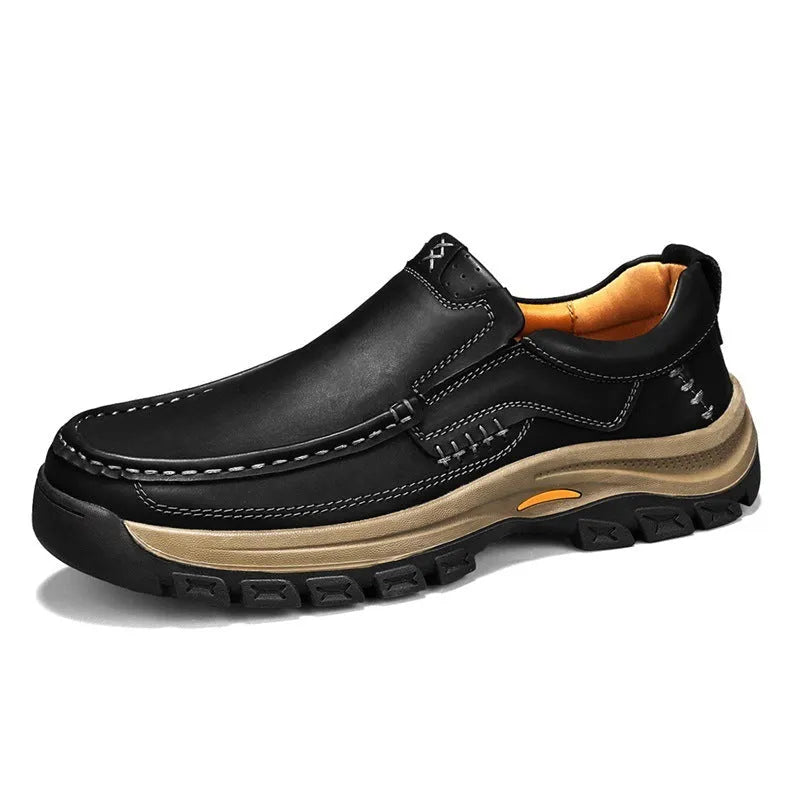 Men's black leather mountaineering shoes with thick rubber soles and round toe on a neutral background.