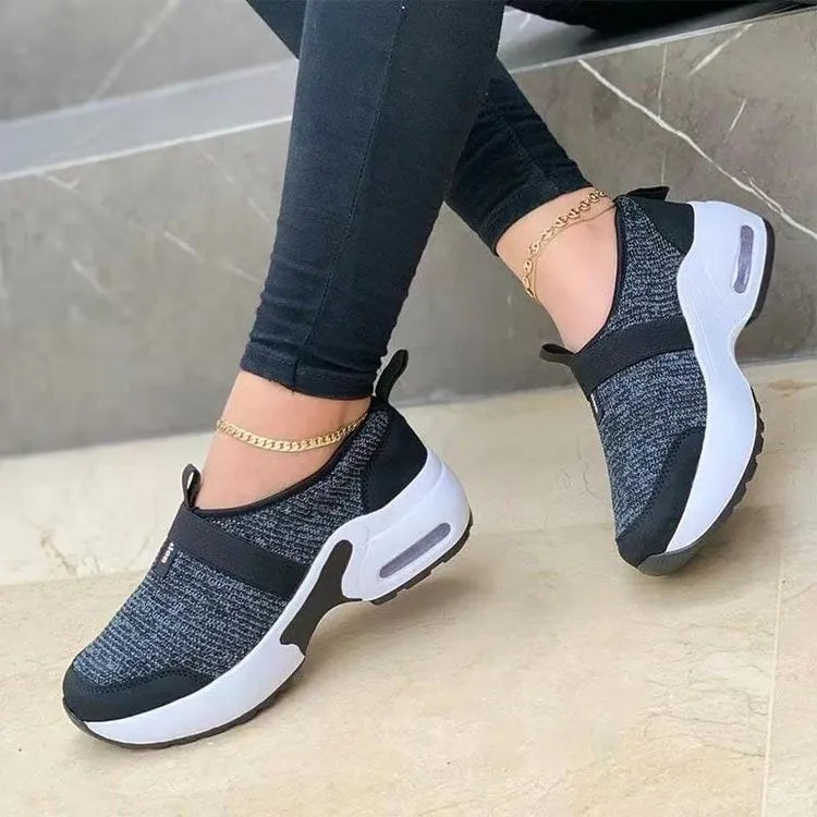 Women's flat mesh sneakers in light grey with white rubber soles and colour stitching.
