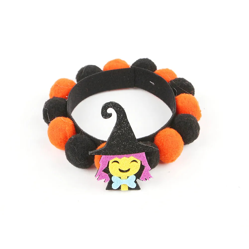 Halloween dog collar with a large orange pom-pom and pumpkin design on an adjustable black band.