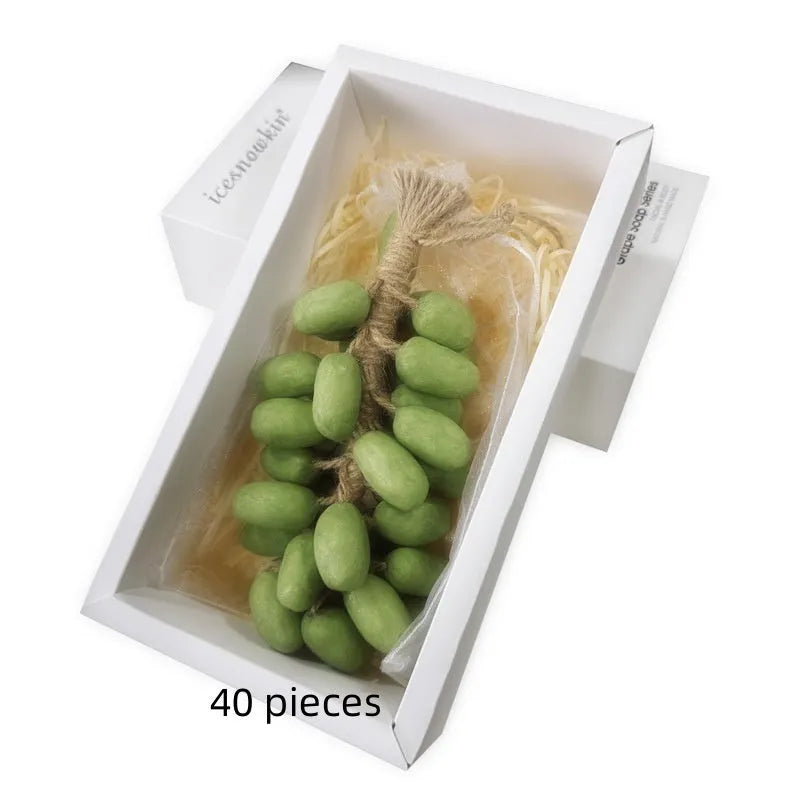 Handmade grape soap bars in black, green, and purple grape scents alongside litchi soap, with gift box and mesh bag packaging
