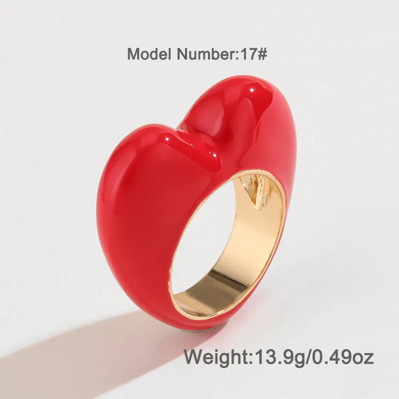 Close-up of a heart-shaped ring with a raised red enamel heart on a metallic band.