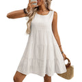 A woman wearing a light blue sleeveless plaid dress with an oversized swing skirt and high waist.