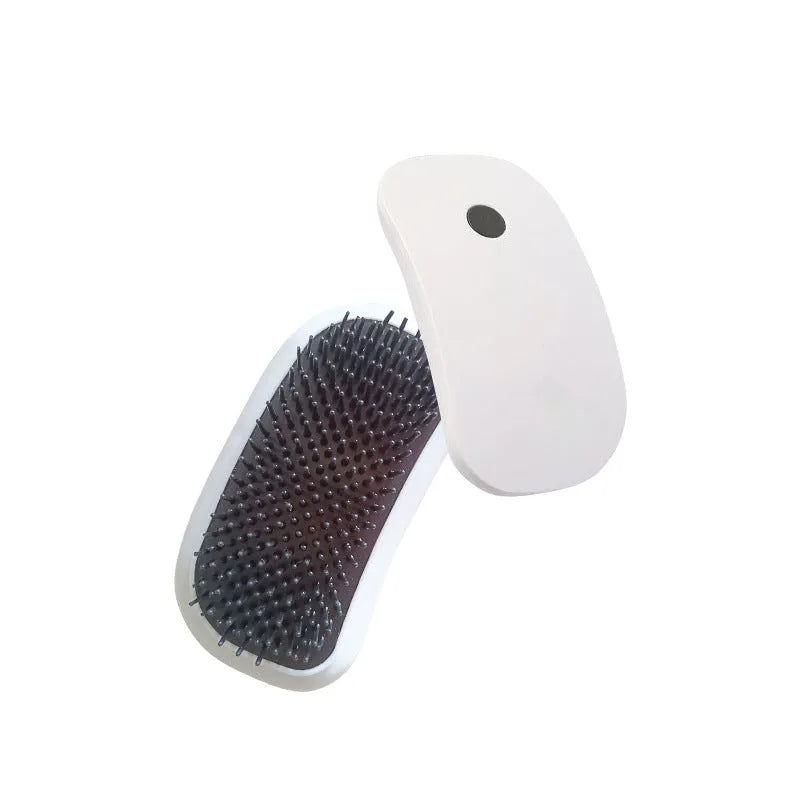Handheld pink and white electric pet massage brush for cats and dogs on a table.