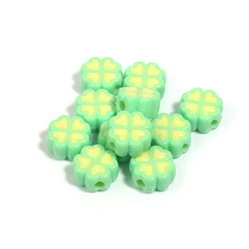 A pile of 15mm frosted acrylic four-leaf clover beads in mixed colours including pink, green, and blue.