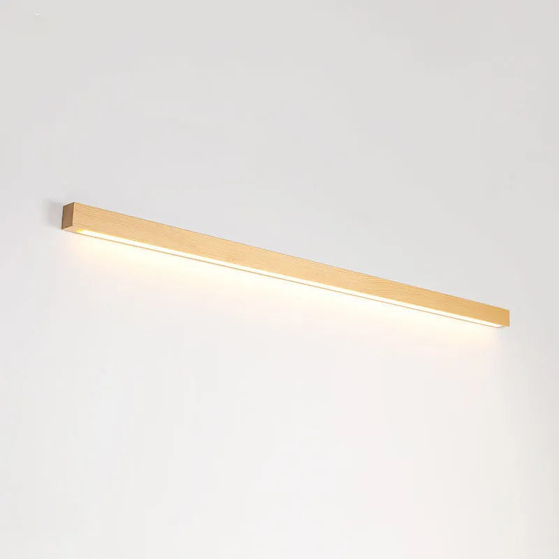 Walnut coloured log strip wall lamp with a square wood and acrylic profile mounted on a wall.