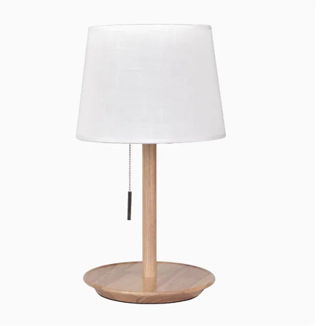 Walnut coloured solid wood desk lamp with a white fabric lampshade and a cable switch.
