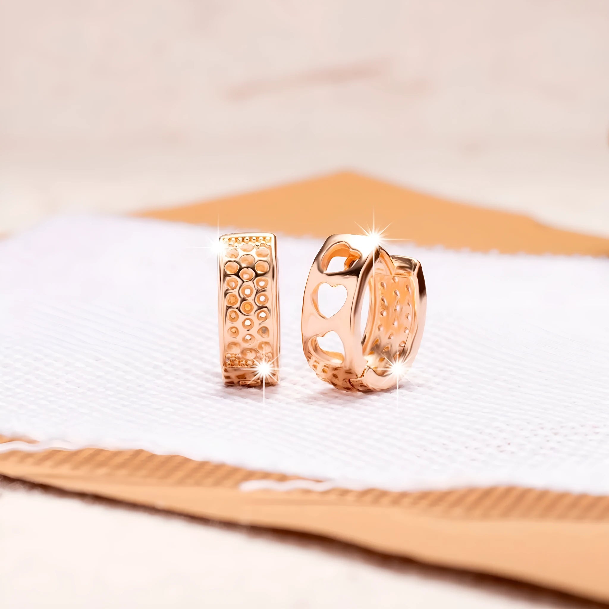 Rose gold electroplated earrings with three hollow heart shapes in circular design