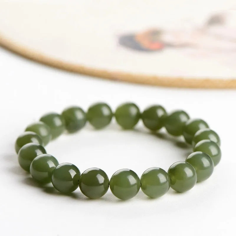 A polished Hetian jade bead bracelet in a light ice-clear colour, showing smooth round beads on a string.