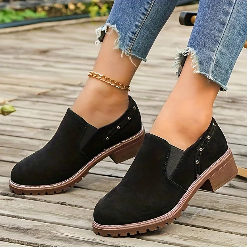 Women's light brown suede ankle boots with a low stout heel and elastic band at the ankle.