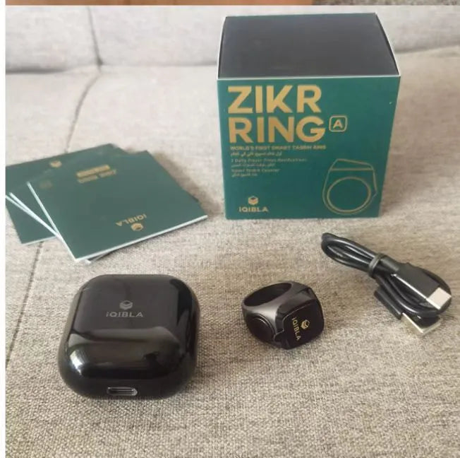 Zikr1 smart ring showing OLED display with time and count, metal body, on a finger.