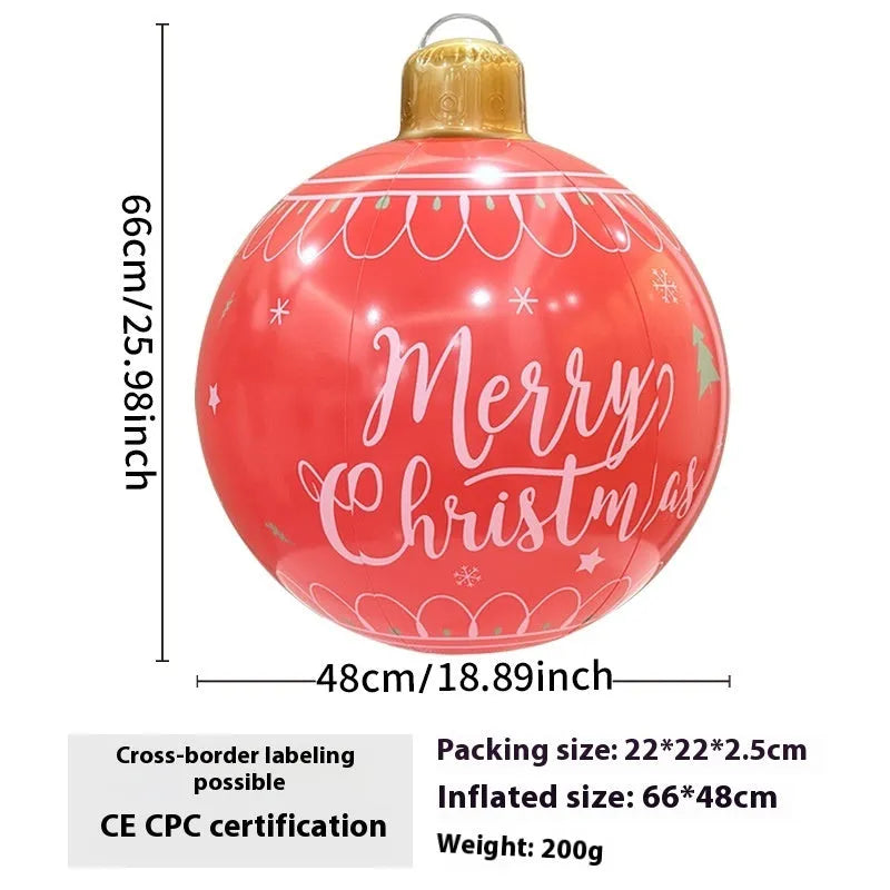 Large red and white inflatable Christmas ball with snowflake design in garden setting