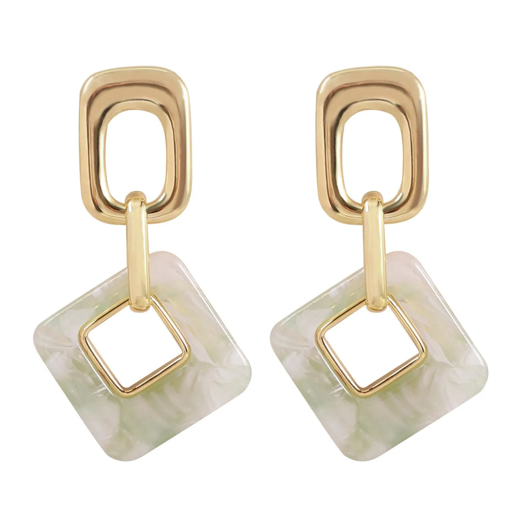 A pair of hollow geometric square copper earrings with a chamfered pattern design.