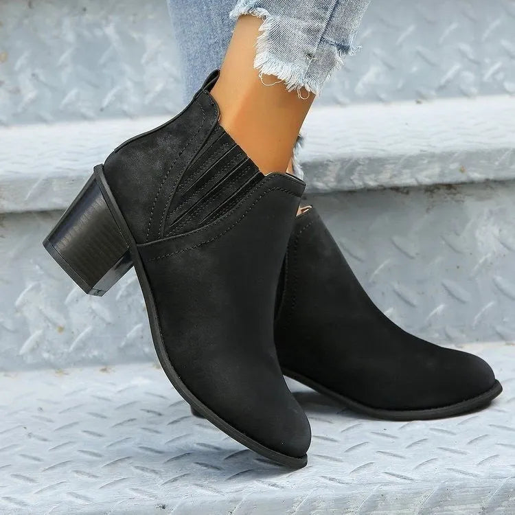 Black women's ankle boots with a pointed toe, thick square low heel, and slip-on design on a white background.