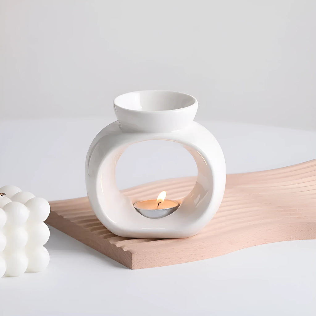 White ceramic Nordic-style aromatherapy stove ornament on a wooden surface.