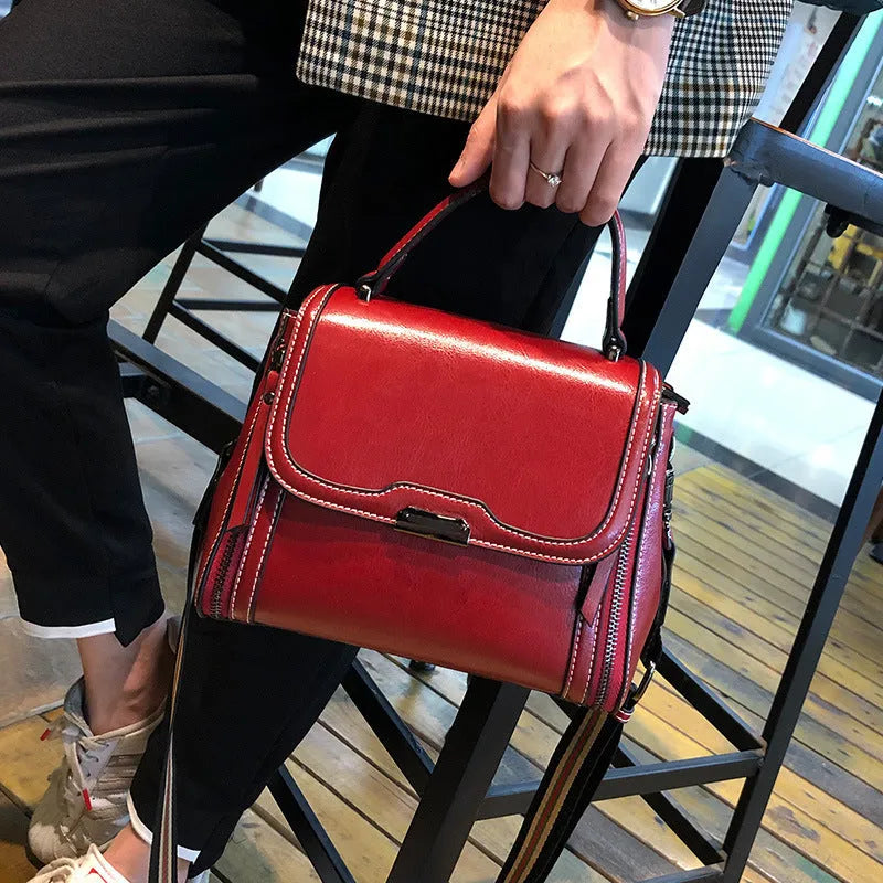 Women's brown genuine oil wax leather messenger bag with double strap and external pocket.