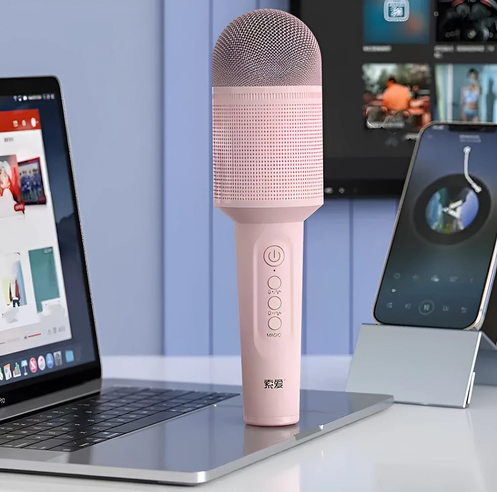 Wireless Bluetooth karaoke microphone in girly pink colour with integrated speaker grill and USB port.