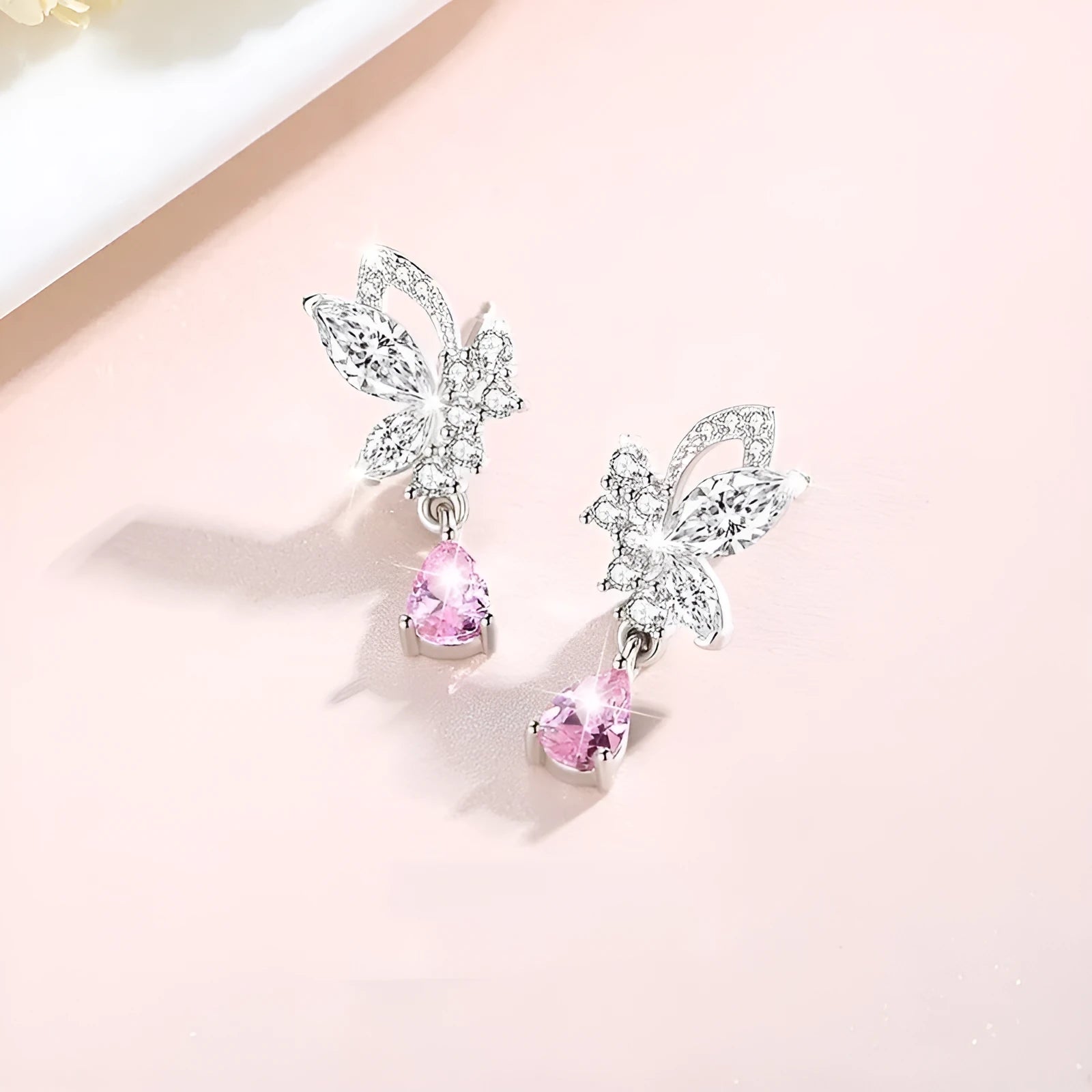 A pair of sterling silver butterfly stud earrings with crystal details on a white background.