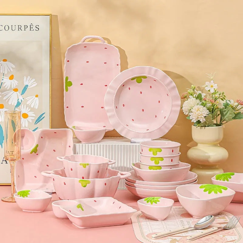 Porcelain dinnerware set with strawberry design showing plates, flower bowls, and twist spoon