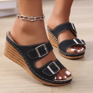 Women's creamy-white beach slippers with an outer wedge belt buckle on a flat rubber sole.