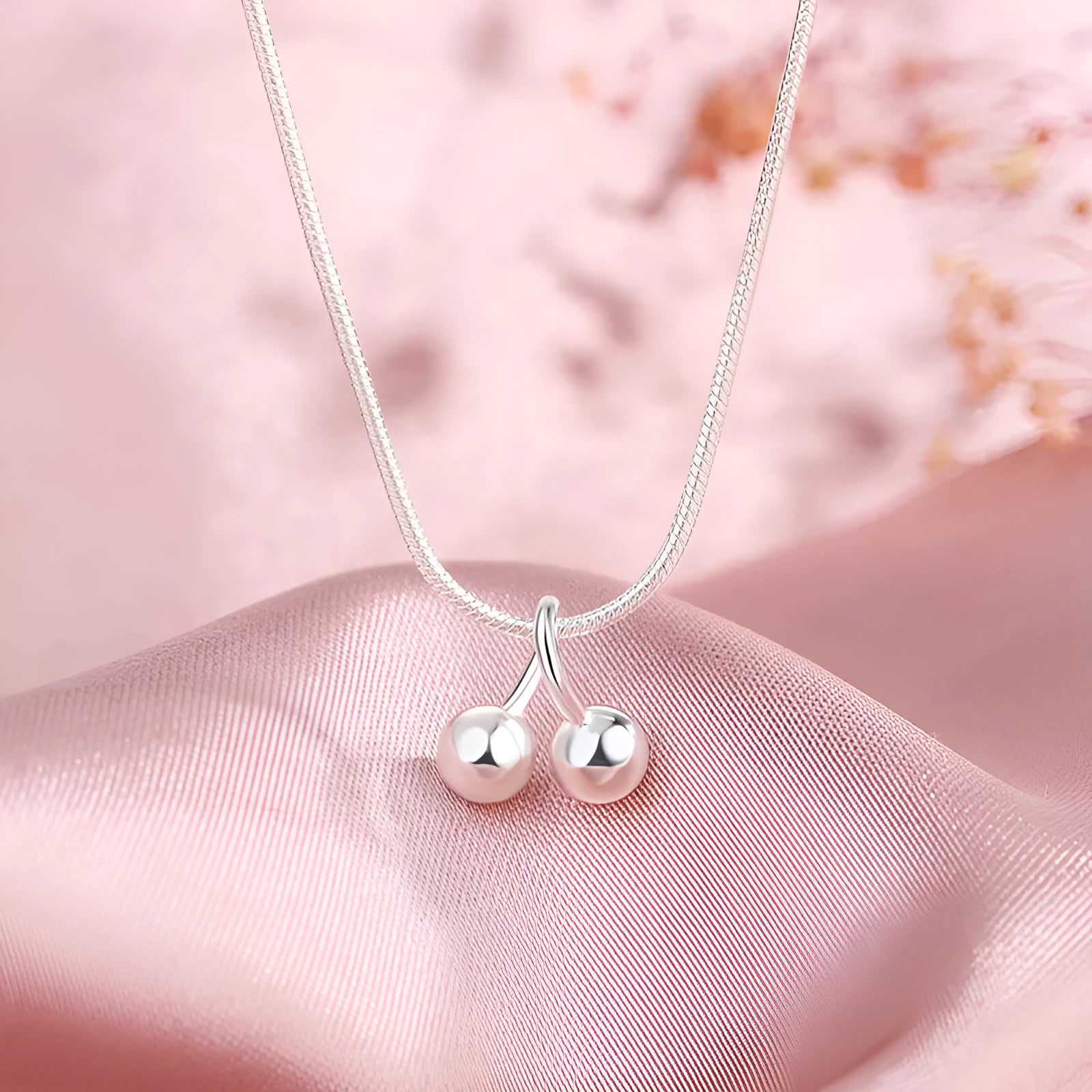 Silver cherry pendant necklace on an adjustable snake bones chain for women.
