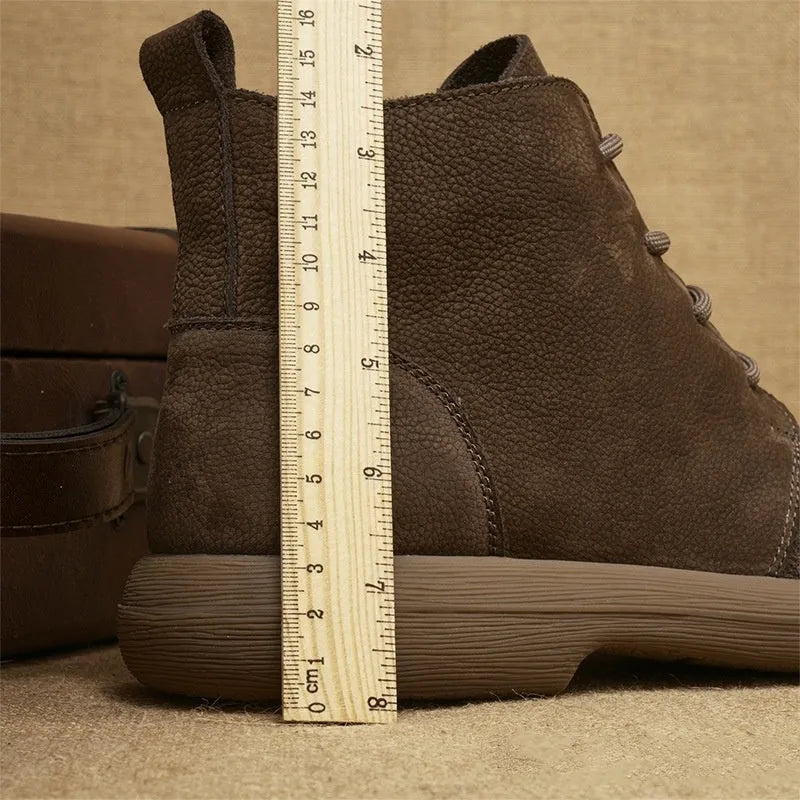 Grey genuine leather martin boots with wedge heel and front lace-up fastening on a neutral background