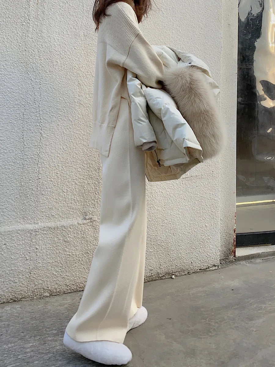 Women's high waist wide-leg knit trousers in cream white colour, laid flat to show straight-leg cut.