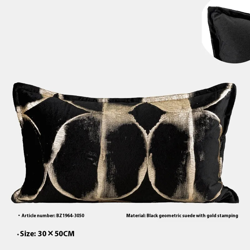 Black and gold abstract pattern flannel decorative cushion on a grey sofa.