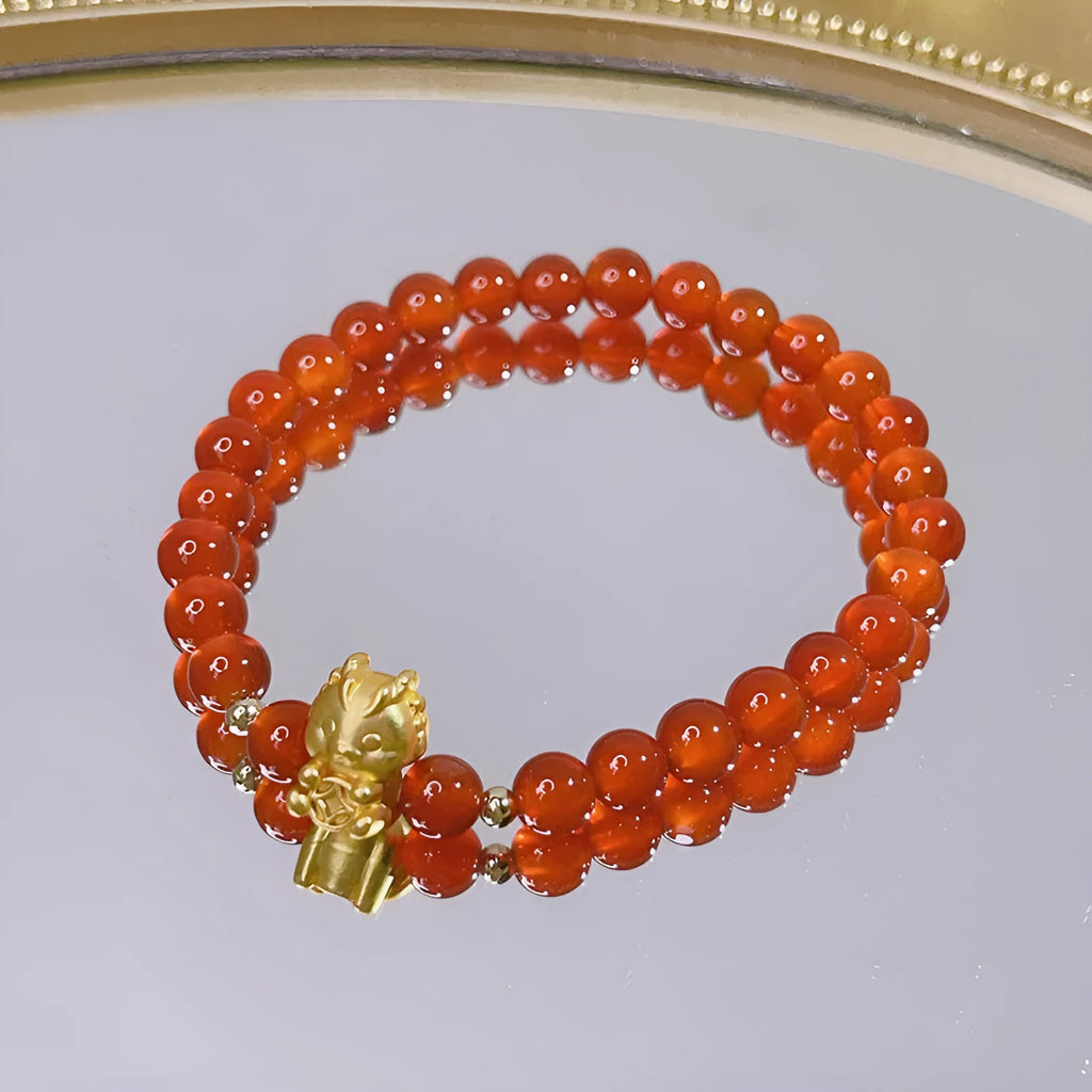 A red agate bracelet for women with Chinese style dragon and lucky bag motifs.