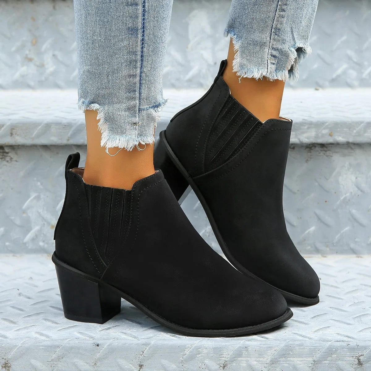 Black women's ankle boots with a pointed toe, thick square low heel, and slip-on design on a white background.