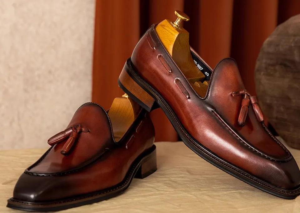 Men's brown leather loafers with fringed detail and slip-on design on rubber sole